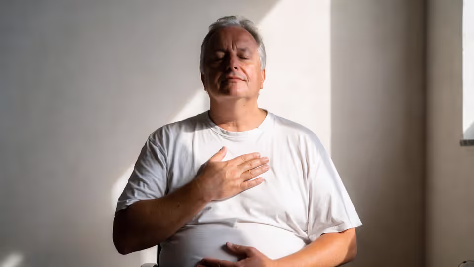 A person in a relaxed position with closed eyes, practicing relaxation