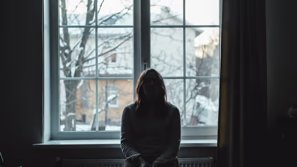 Adult sitting indoors during winter light with low mood